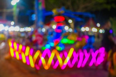 Gece festivalinde Bokeh 'le yemek standının bulanık görüntüsü. Gece festivali şehir parkındaki soyut fotoğraf bulanık insanlar gece renkli ışıklarla arka plan bokeh.