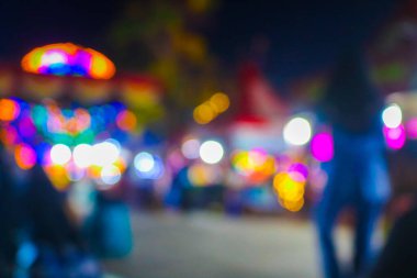 Gece festivalinde Bokeh 'le yemek standının bulanık görüntüsü. Gece festivali şehir parkındaki soyut fotoğraf bulanık insanlar gece renkli ışıklarla arka plan bokeh.