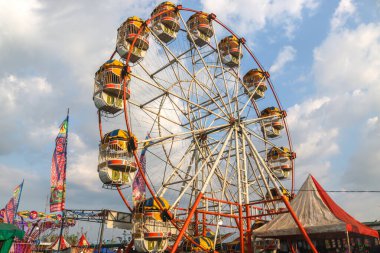 Kulon Progo - 29 Eylül 2024: Dönme dolap. Lunaparktaki kuş kafesi şeklinde bir kulübe, lunapark festivali. Öğleden sonra dönme dolap manzarası