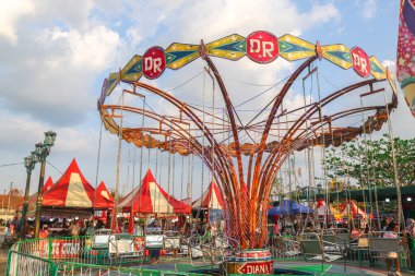 Endonezya - 29 Eylül 2024: Lunaparkta gün batımıyla birlikte atlıkarınca gezisi, eğlence festivali. Atlıkarıncanın boş koltukları gece pazarında geziniyor.