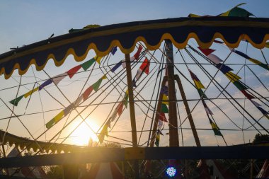 Öğleden sonra eğlence parkında gün batımında atlı karınca gezintisi, eğlence festivali. Atlıkarıncanın boş koltukları gece pazarında geziniyor.