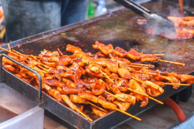 Şefin ellerini mangalda sosis, ızgara kalamar, barbekü, ızgarada meşale ateşiyle yakın. Barbekü sokak yemeği.