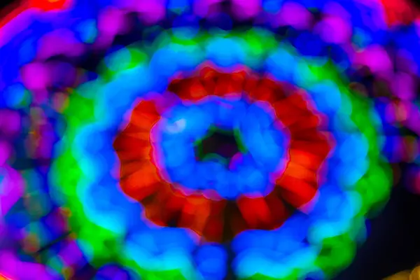 Gece festivalinde Bokeh arka planlı dönme dolabın bulanık görüntüsü. Gece festival şehir parkındaki oyun sürüşlerinin soyut bulanık fotoğrafı gece renkli ışıklarla bokeh arka plan.