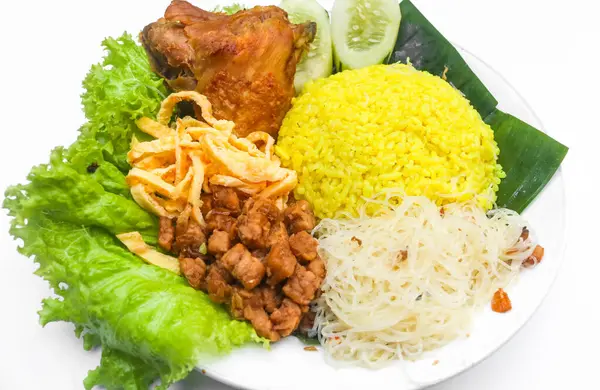 Tavuklu pilav, tempeh, omlet, erişte ve biber sosu tabakta servis edilir. Endonezya tarzı sarı pirinç