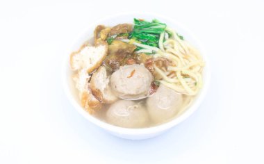 Erişte, tofu, kereviz ve beyaz arka planda izole edilmiş beyaz bir kasede servis edilen etle dolu Endonezya usulü çorba köfteleri. Beyaz kasede soslu köfteleri kapat.