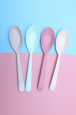 Beyaz arka planda izole edilmiş farklı renkli plastik kaşıklar. Renkli kaşık takımı