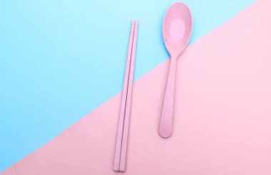 Araçlar mavi arkaplanda renkli çatal, yemek çubuğu ve kaşık izole edilmiş.