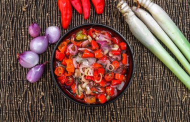 Endonezya Balili sambal matah 'ı mutfak baharatlarıyla süslenmiş bir kasede servis edildi. Acı biber, limon otu, soğan, limon yaprağı gibi ham baharatlardan yapılan bir çeşit kırmızı biber sosu..