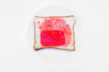Beyaz tost ekmeğini bir tabakta çilek reçeli ile kapat, beyaz arka planda izole edilmiş dilimlenmiş ekmek..