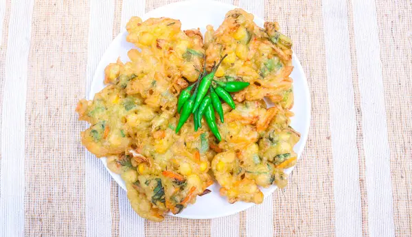 Sebzeli bakwan, mısır böreği geleneksel Endonezya yemeğidir. Un börekleri mısır, lahana, havuç, kereviz gibi sebzeler içerir. Bakwan beyaz tabakta servis edilir.