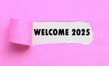 Beyaz arka plan ve yırtık pembe kağıt 2025 'e hoş geldiniz. Yeni yıl kavramı ve tipografik karşılama 2025 kağıt üzerinde
