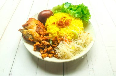 Tabakta tavuk, tempeh, yumurta, erişte ve biber soslu sarı pirinç servis edilir. Endonezya tarzı sarı pirinç