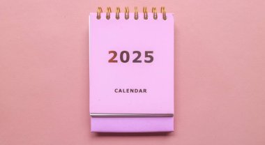 2025 takvimi pembe arka planda izole edilmiş. Takvim ve Not Defteri Mutlu yıllar 2025. 2025 Yeni Yıl Kararları Hedef, Plan ve Eylem Konsepti