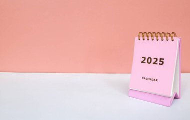 2025 takvimi pembe arka planda izole edilmiş. Takvim ve Not Defteri Mutlu yıllar 2025. 2025 Yeni Yıl Kararları Hedef, Plan ve Eylem Konsepti