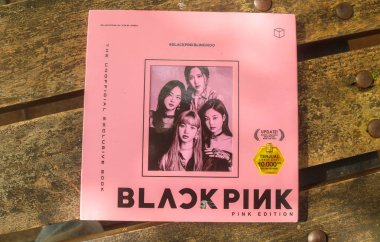 Endonezya - 5 Aralık 2024: Bahçe masasında siyah pembe kitaplar. Güney Koreli KPop şarkıcılarının kitapları. Güney Kore BlackPink müzik grubunun fotoğrafçısı.