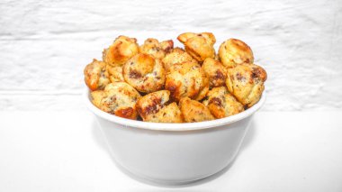 İçi çikolata dolu Choux Pastası beyaz arka planda izole edilmiş bir kaseyle servis ediliyor. Çikolatalı choux keki yuvarlaktır.