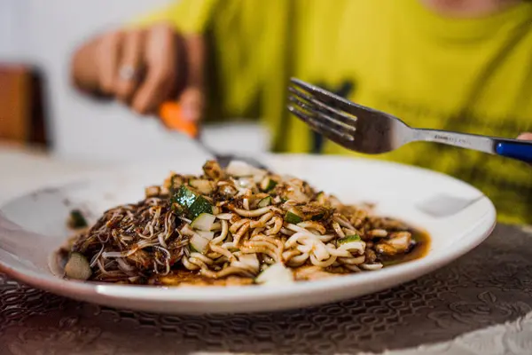 Birisi bir tabak pempek lenggang yemek üzere ve yakından çekilecek.