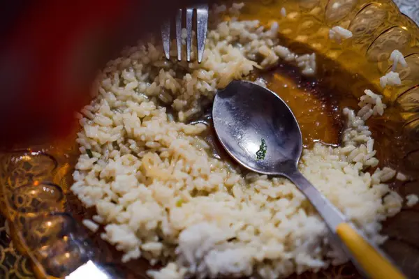 Birisi bir tabak pirinci tepeden tırnağa yiyor.