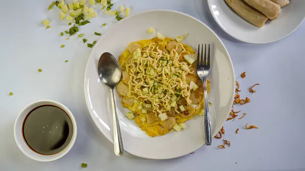 Bir tabak pempek lenggang, bir kase cuko sosu, süslenmiş ve tepeden tırnağa çekilmiş.
