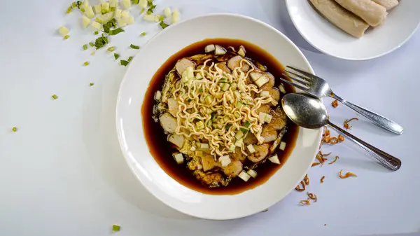 Bir tabak lezzetli pempek lenggang ve cuko sosu.