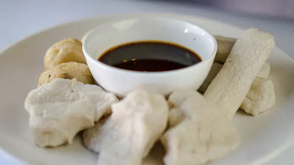 Sirke sosuyla birlikte bir tabak karışık pempek.