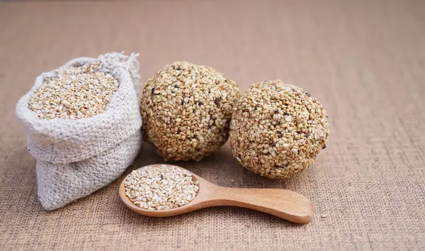 Geleneksel Hint tatlıları susam tohumları, jaggery ve hindistan cevizi ile yapılır, yaygın olarak Til ke laddu ya da susamlı ladoo olarak bilinir. Kahverengi arkaplanda çekilen