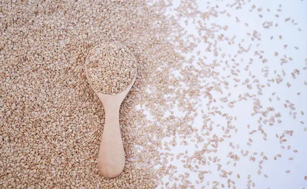 kaşık arkaplanındaki susam tohumlarını kapat