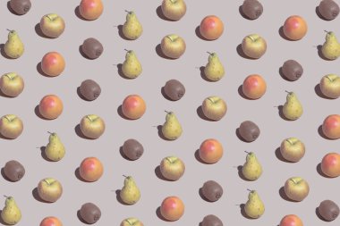 Creative pattern with apple, orange, pear and kiwi. Beige background aesthetic. Summer fruit layout.
