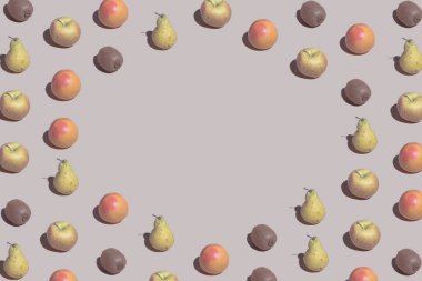 Taze greyfurtlardan, kivilerden, pastel bej arka planda elmalardan ve armutlardan oluşan yaratıcı desen. Yaz meyvesi düzlüğü