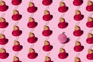 Pembe arka planda dekoratif Noel çanları. Noel ve yeni yıl yaratıcı desen.