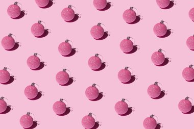 Pembe arka planda süslü Noel süsleri. Noel ve yeni yıl yaratıcı desen.