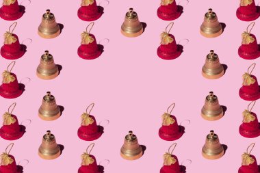 Pembe arka planda dekoratif Noel çanları. Noel ve yeni yıl yaratıcı kopya alanı