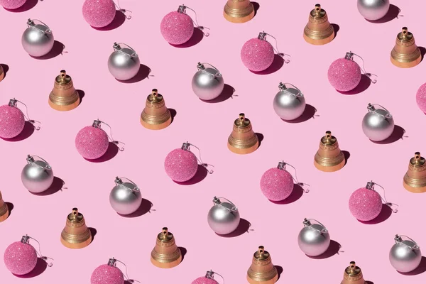 Altın ve gümüş noel mücevherleri ve pembe arka planda ziller. Noel ve yeni yıl yaratıcı desen.