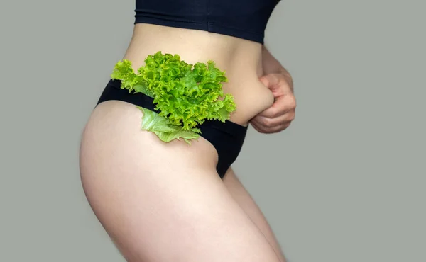 slim woman eating salad leaf lettuce sexy belly postpartum after childbirth.woman thumbs up for fit abdomen and down for fat.girl in underwear