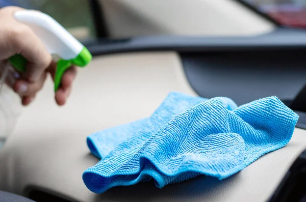 car wash and interior chemical cleaning concept.hand use microfiber cloth and spray to clean lateral door from inside,retractable rear view mirror,steering wheel.modern hybrid vehicle clean inside