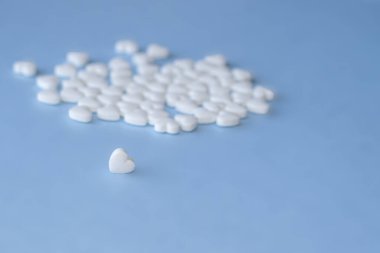 pills isolated medicine medical concept.white round red heart shaped pills chaotic or in row on green blue black orange paper from bottle disease treatment.arrow from tablets money coin plastic blister