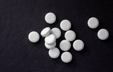 pills isolated medicine medical concept.white round red heart shaped pills chaotic or in row on green blue black orange paper from bottle disease treatment.arrow from tablets money coin plastic blister