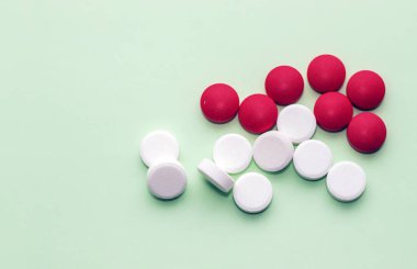 pills isolated medicine medical concept.white round red heart shaped pills chaotic or in row on green blue black orange paper from bottle disease treatment.arrow from tablets money coin plastic blister