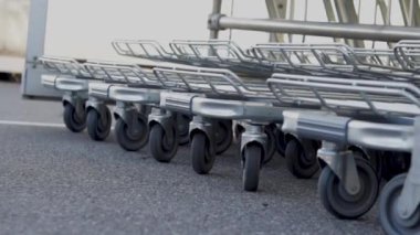 many trolley shopping cart with coin lock anti theft system outside in row sunny day different angles blue handle chain blocked carts,details.man analysis receipt prices money spent next to car