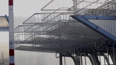 many trolley shopping cart with coin lock anti theft system outside in row sunny day different angles blue handle chain blocked carts,details.man analysis receipt prices money spent next to car