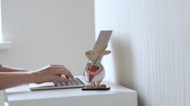 work from home remote job woman using laptop for business communication meeting fun.female girl maternity leaves on baby bed or minimalist small table hands gestures.red paper heart wooden rabbit toy 