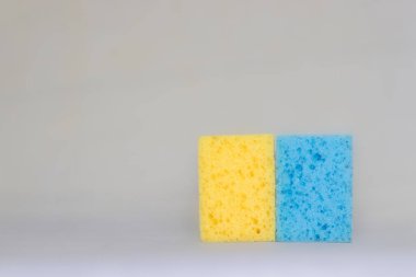 two sponges for cleaning. yellow, blue colors. space for text. Kitchen cleaning set sponge background. sponge in womans hand. space for text. 