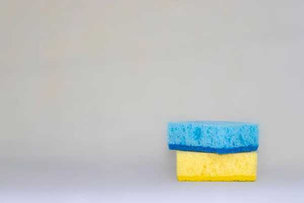 two sponges for cleaning. yellow, blue colors. space for text. Kitchen cleaning set sponge background. sponge in womans hand. space for text.