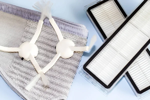 robot vacuum cleaner accessories set. vacuum hepa filter,coverage mop cloth and cleaner side brushes. white blanket or light blue background. housekeeping concept