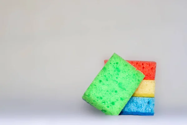 Multicolored sponges for cleaning. blue, green, red, yellow, blue and green colors. space for text. Kitchen cleaning set sponge background.