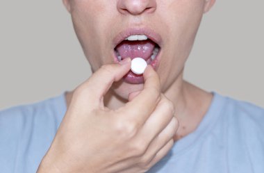 sore throat and runny nose treatment. woman using lozenge candy spray for red painful throat or nose sprayer isolated.girl coughing hold hand on neck or mouth.feeling pain,respiratory virus infection