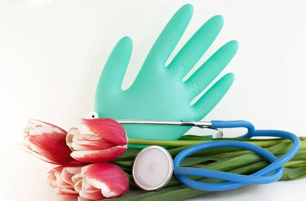 Eldivenden alınan kırmızı lale buketi steteskobu balonu yalıtılmış tıbbi konsept ilkbaharı veya profesyonel doktor hemşire asistanı tatili. Metin reklamcılığı afişi için boş yer.