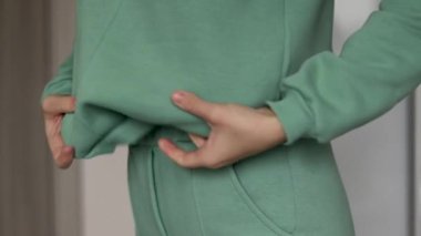 Kadın bir takım elbise giyiyor kısa pantolon ya da beyaz t-shirt giyiyor. Gardırobu açıyor, iç çamaşırları dağıtıyor. Üst raftan bazı giysiler sürüklüyor. 