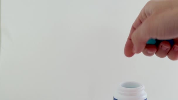 蓝色糖果 用于妇女手的喉痛治疗软胶囊 或把一个接一个放在塑料瓶里 掉下来的药丸桌 带外科手套的医用听诊器 背景医学概念 — 图库视频影像