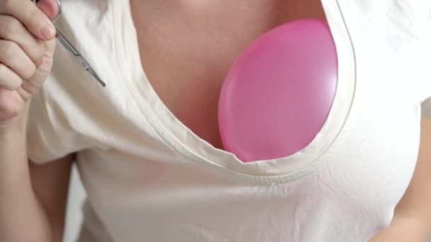 女人抱着两个粉色紫色充气气球在胸部跳舞 用身体做一些动作 手用剪刀打破气球视频慢动作 — 图库视频影像